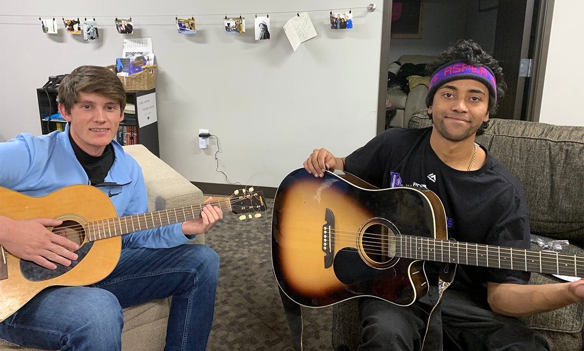 Andrew Sawyer (left), sophomore biochemistry major, and a Dry Bones friend enjoy an impromptu guitar session while hanging out at the ministry's headquarters.