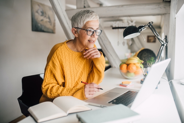 Older woman working on laptop, online degree programs