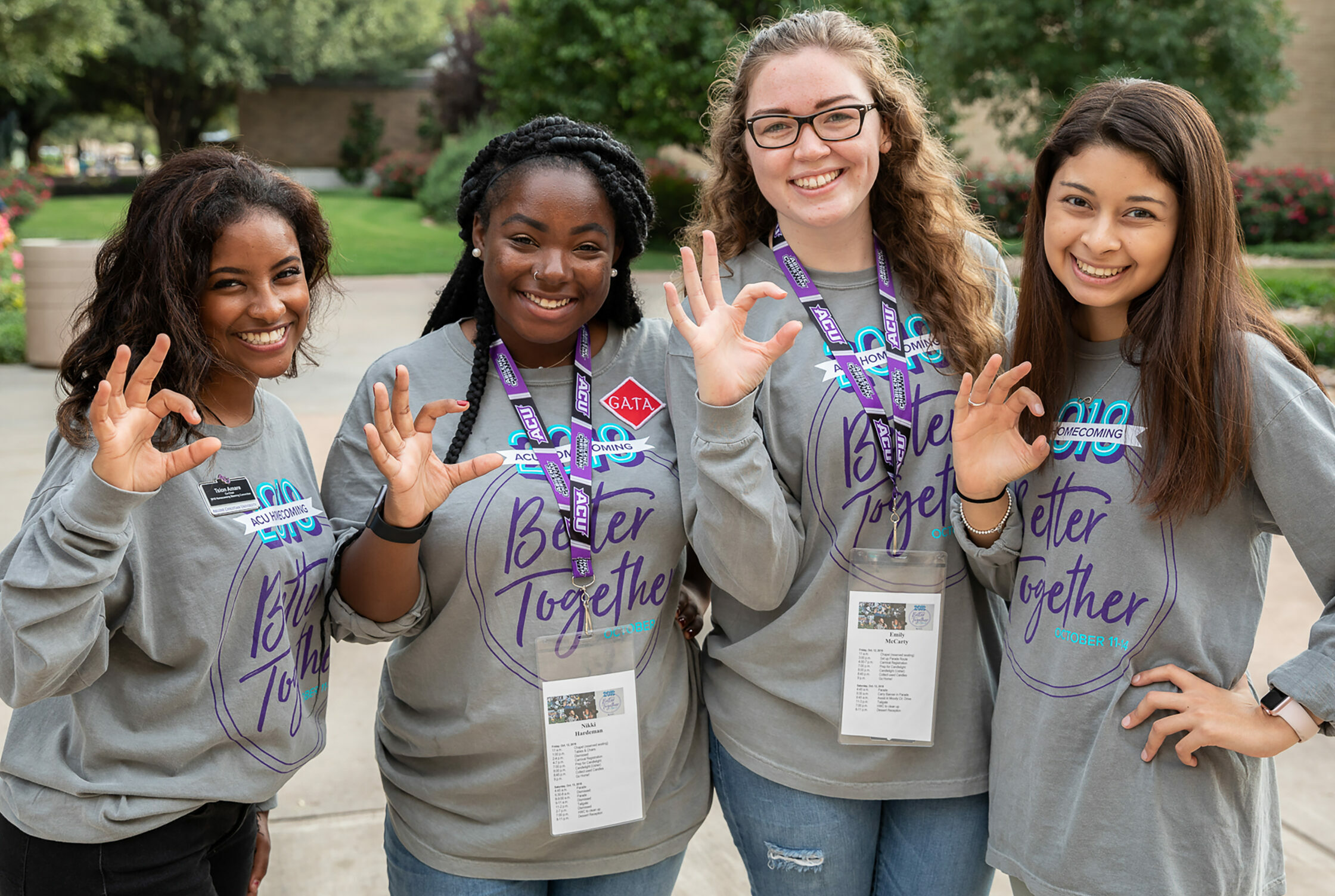 Four ACU students making the W-C hand symbol