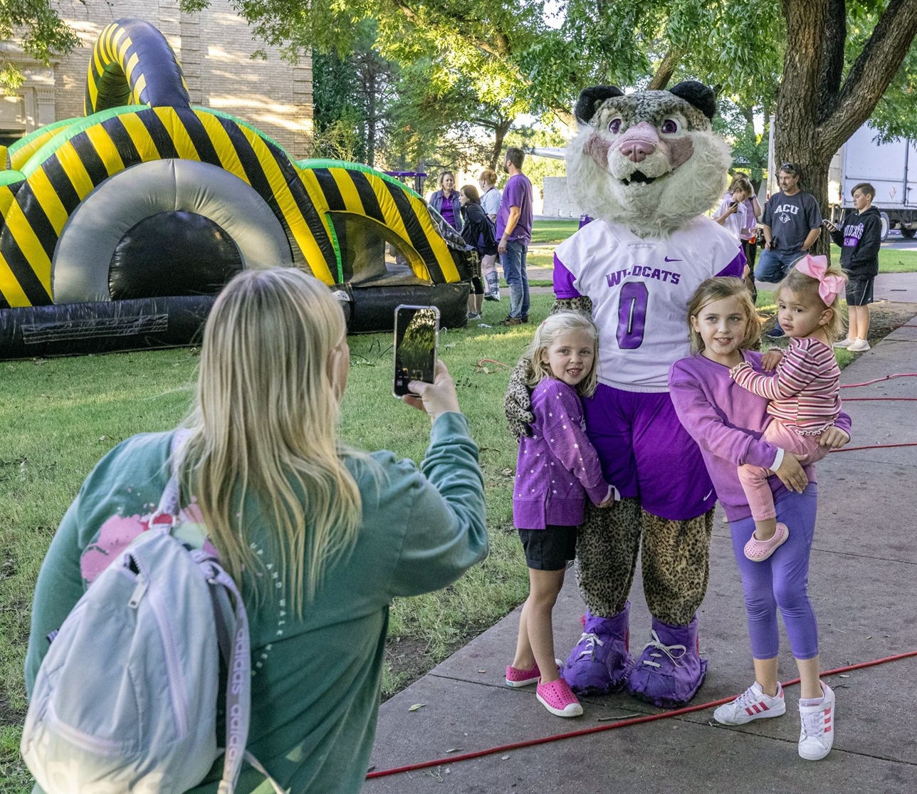 Willie the Wildcat poses with young visitors during ACU’s 2021 Homecoming.
