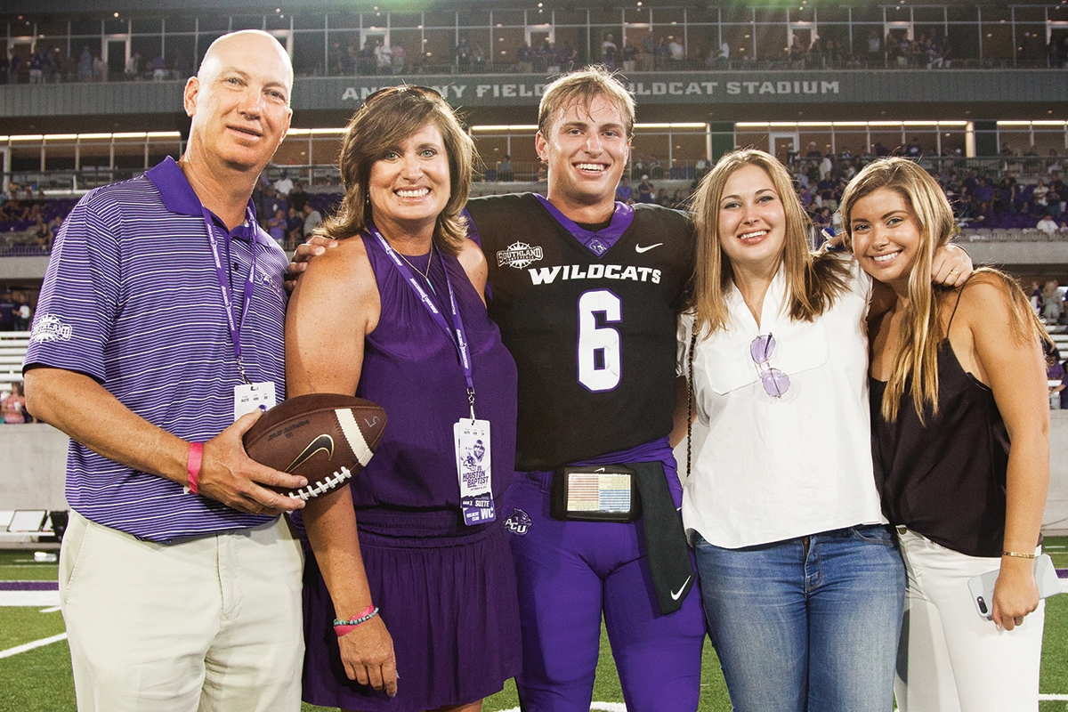 Mark and April Anthony celebrate on the field after the opening game at Anthony Field at Wildcat Stadium with their son, Luke, and their daughters, Ashlyn and Allie.