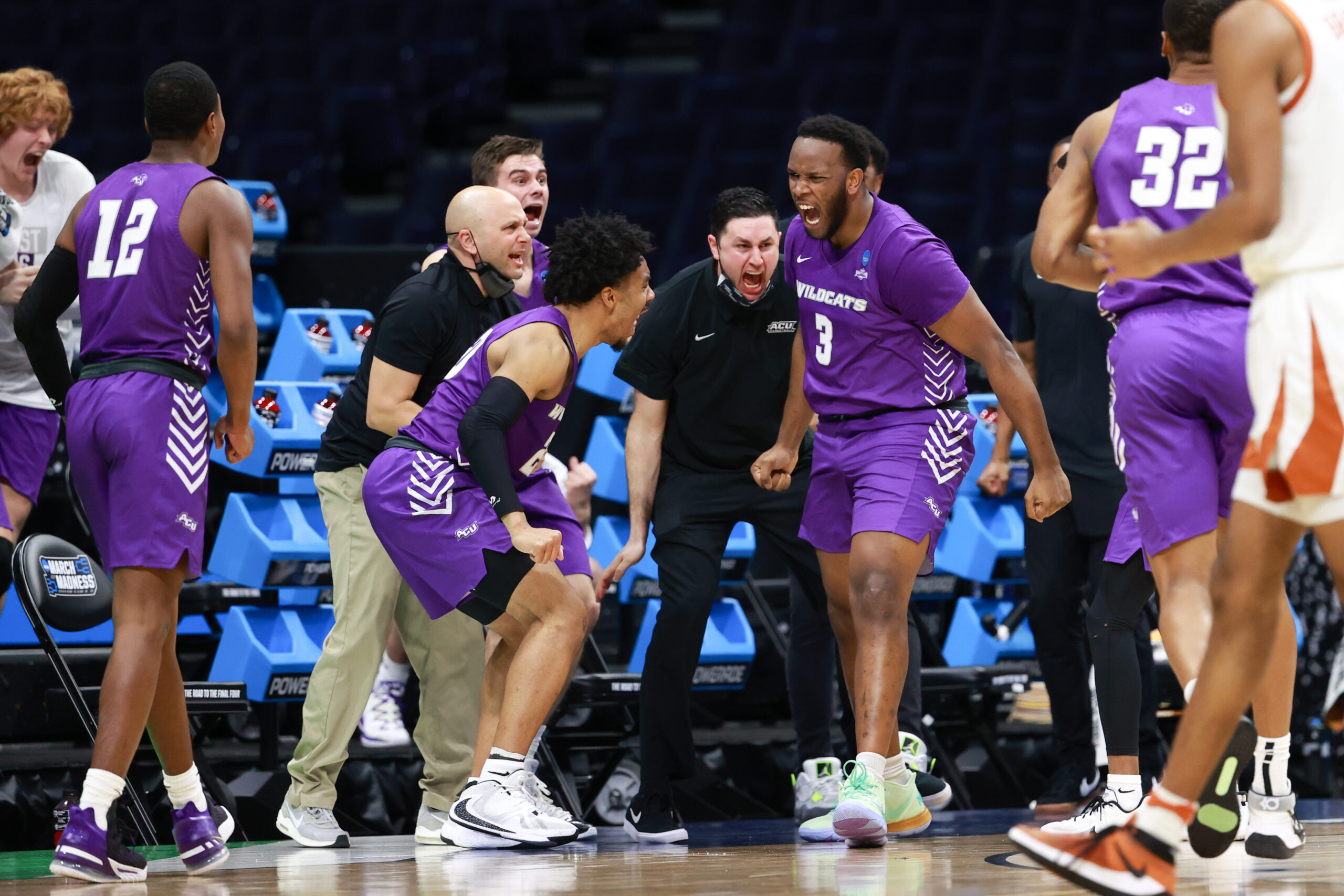 Joe Pleasant, whose two late free throws and stolen pass sealed ACU’s upset win over Texas, leaps with joy while leading teammates off Unity Court at Lucas Oil Stadium in Indianapolis during the NCAA Tournament.