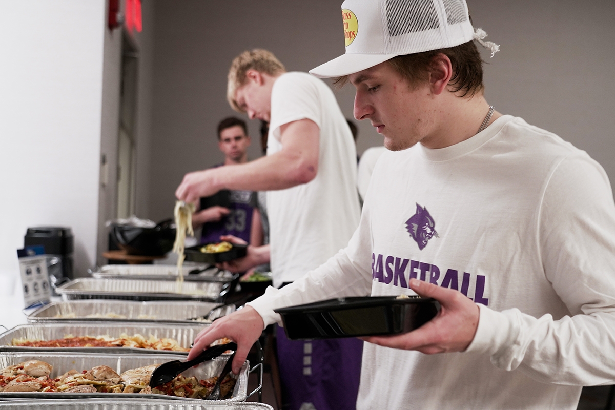 Freshman guard Logan McLaughlin (right) and senior center Kolton Kohl fill their plates from the buffet on the floor of The Westin Indianapolis during the NCAA Tournament.