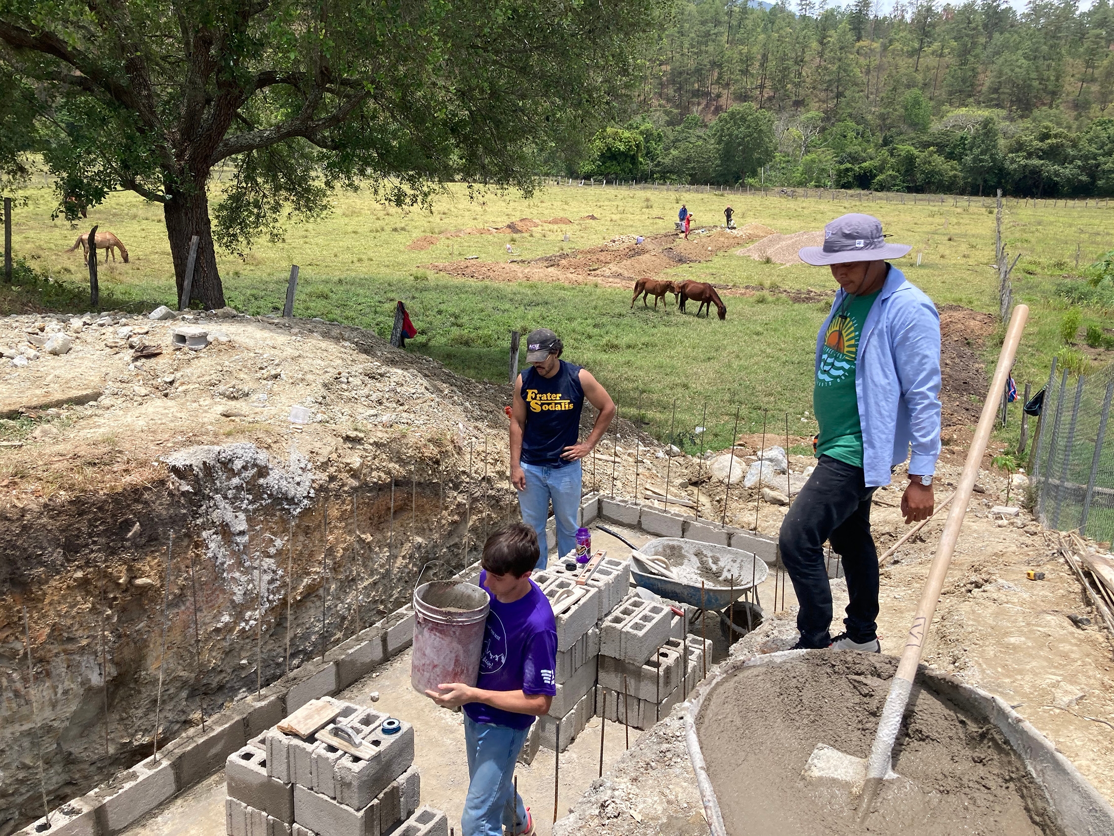 Engineering majors Josh Dowell (front) and Nate Hartin (center back) work with Hondurans to build a wastewater treatment system for a new children’s home.