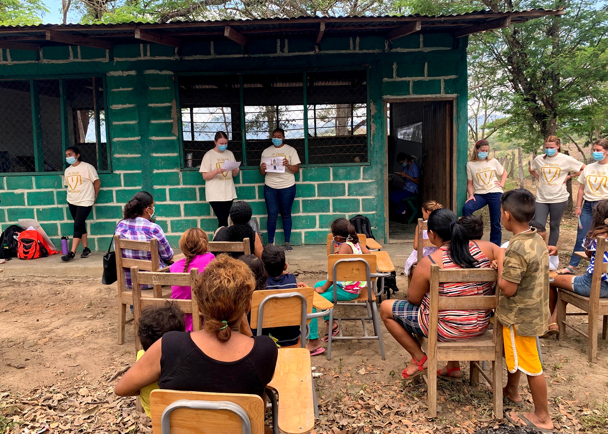 Nursing student Addy Boston (center left) talks about the importance of wearing shoes during a community presentation on sanitation and hygiene. To her right is a Honduran translator.